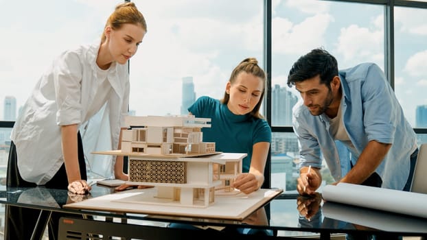 Smart architect team discussion about house design while handsome male worker present idea by using laptop. Group of professional engineer sharing, brainstorming design. Business design. Tracery