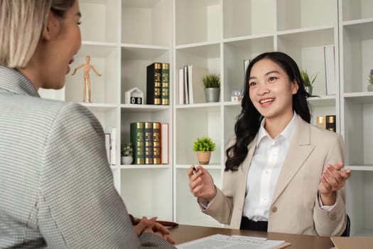 A young lawyer and businesswoman are discussing legal advice on signing a business contract. Insurance or financial contract signing.