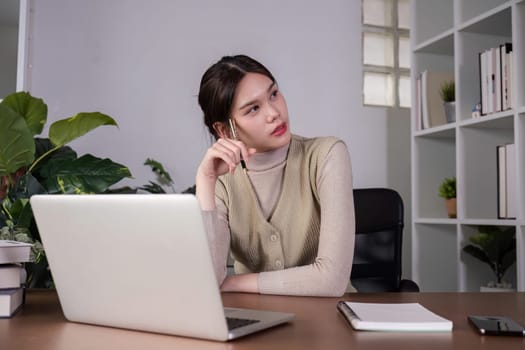 Asian female student studying online Video calls through Zoom about business administration and accounting subjects attentively.