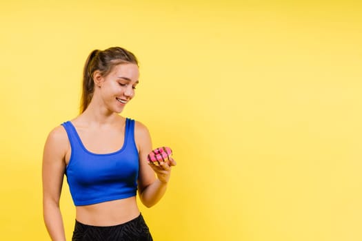 Young cute sport woman eating donut cake in studio background