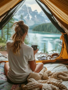 A woman is sitting in a tent by a lake, holding a cup of coffee. Concept of relaxation and tranquility, as the woman enjoys her coffee in a peaceful outdoor setting