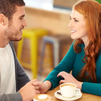 Restaurant, date and couple with coffee, holding hands and relationship with romance and flirt. Cafe, man and woman with cappuccino or bonding together with care or love with marriage, smile or trust.
