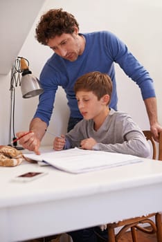 Teen, dad and help with studying in home, student and support for assignment or project. Daddy, boy and schoolwork on weekend in bedroom, education and assistance or guidance for learning by desk.