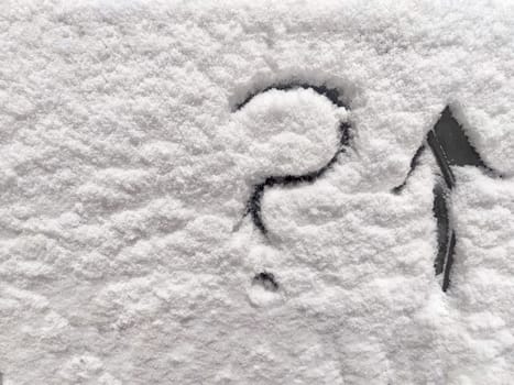 Question mark and arrow written in the snow. The cold frosty texture of the snow and the question mark. Background, place for text, copy space