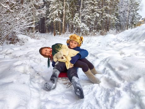 Two cute happy little cheerful children having fun in winter snow forest. Photo shoot in stylized clothes of the USSR. Fur Hat with earflaps