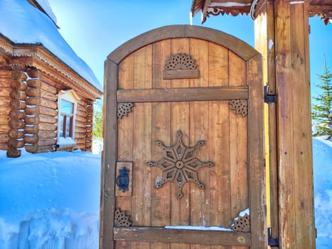 Ornate wooden gates with carvings and snow. Traditional Carved Wooden Gates in Winter day