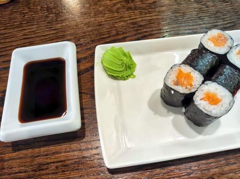 Sushi rolls with fresh ingredients served on platter. Japanese Sushi Rolls on White Plate With Ginger Garnish. Blurred and Partial focus