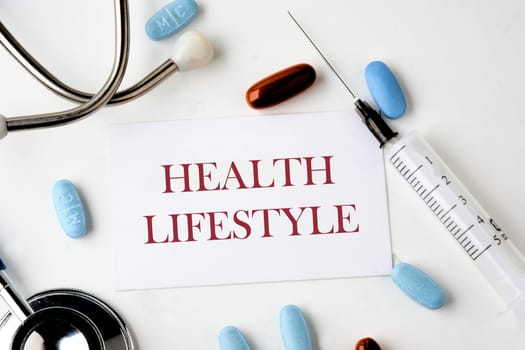 Medical concept. HEALTH LIFESTYLE text. words on the card near the stethoscope, pills, syringe on a white background