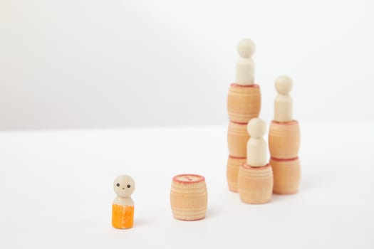 Three wooden figures on high pedestals and one separately near them. The difficulty of starting the journey. To reach the top you need to start. Business, achievement, success