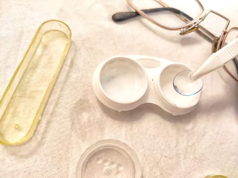 Set for contact lenses with a container, forceps, glasses. The concept of correcting myopia. Contact lens care, cleaning, health. Background, copy space