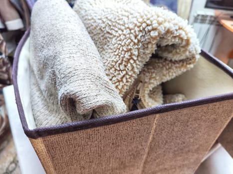 Organized Clothing Storage Using Konmari Folding Method. Neatly folded clothes arranged vertically in a storage box