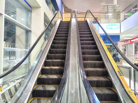 Arkhangelsk, Russia - February 28, 2024: Escalator in Modern Shopping Mall. Big Escalator inside a vibrant shopping center