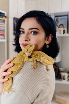 A beautiful woman in a joyful moment, posing with her two adorable bearded dragon pets, radiating love and companionship.