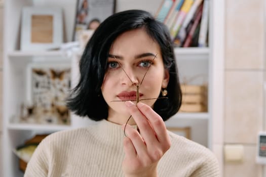 A serene moment as a young woman poses with her beloved stick insect, showcasing the unique bond between human and arachnid.