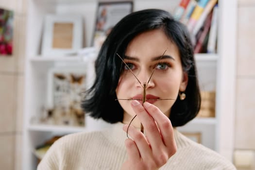 A serene moment as a young woman poses with her beloved stick insect, showcasing the unique bond between human and arachnid.