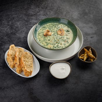 Side view, seasonal cream soup with vegetables on a gray stone background. Restaurant menu
