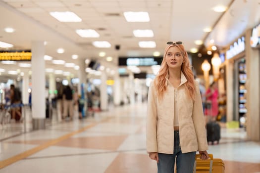 Happy asian tourist woman with luggage traveling between waits for flight in airport terminal, Tourist journey trip concept.