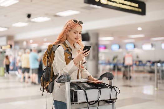 A woman asian walking in an airport. Mobile, suitcase and travel with a young female on an international trip for work or travel.