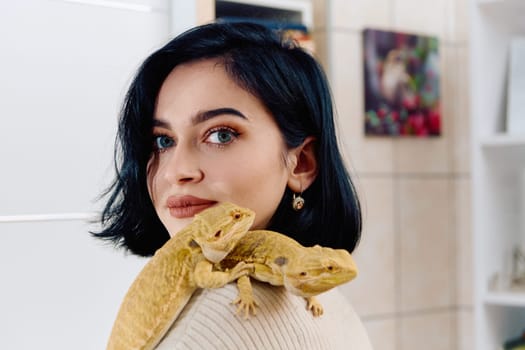 A beautiful woman in a joyful moment, posing with her two adorable bearded dragon pets, radiating love and companionship.