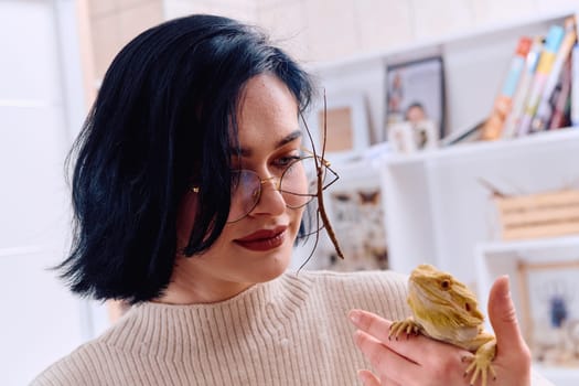 A young woman poses with her two pets, a bearded dragon and a stick insect, in this heartwarming photo.