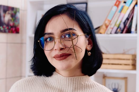 A serene moment as a young woman poses with her beloved stick insect, showcasing the unique bond between human and arachnid.