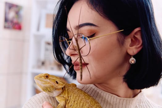 A young woman poses with her two pets, a bearded dragon and a stick insect, in this heartwarming photo.