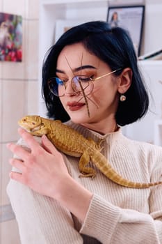 A young woman poses with her two pets, a bearded dragon and a stick insect, in this heartwarming photo.