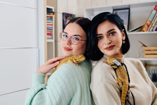 The sisters' smiles and the lizard's calm demeanor suggest that they are all enjoying each other's company.