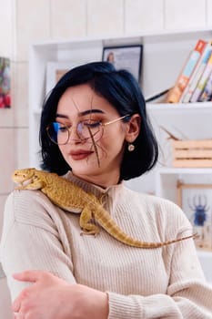 A young woman poses with her two pets, a bearded dragon and a stick insect, in this heartwarming photo.