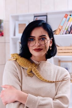 A young woman poses with her two pets, a bearded dragon and a stick insect, in this heartwarming photo.