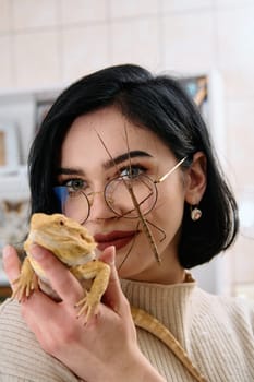 A young woman poses with her two pets, a bearded dragon and a stick insect, in this heartwarming photo.