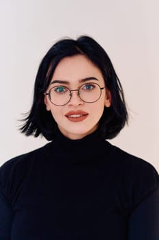 A brunette woman radiates joy as she proudly wears her eyeglasses, showcasing a warm smile against a clean white backdrop