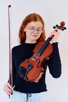 A stunning redhead musician exudes elegance as she poses with her violin, embodying both grace and musical prowess.