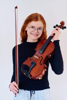 A stunning redhead musician exudes elegance as she poses with her violin, embodying both grace and musical prowess.