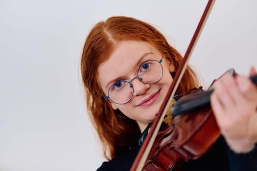 A stunning redhead musician exudes elegance as she poses with her violin, embodying both grace and musical prowess.