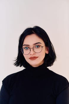 A brunette woman radiates joy as she proudly wears her eyeglasses, showcasing a warm smile against a clean white backdrop