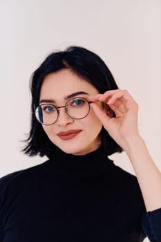 A brunette woman radiates joy as she proudly wears her eyeglasses, showcasing a warm smile against a clean white backdrop