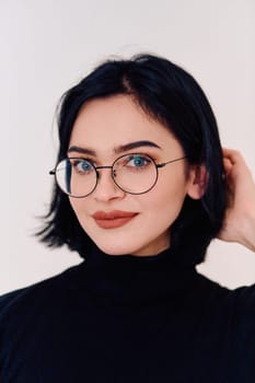 A brunette woman radiates joy as she proudly wears her eyeglasses, showcasing a warm smile against a clean white backdrop