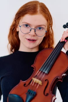 A stunning redhead musician exudes elegance as she poses with her violin, embodying both grace and musical prowess.