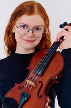 A stunning redhead musician exudes elegance as she poses with her violin, embodying both grace and musical prowess.