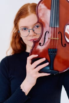 A stunning redhead musician exudes elegance as she poses with her violin, embodying both grace and musical prowess.