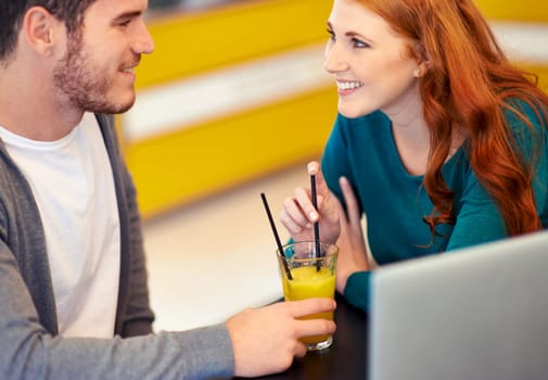 Cafe, laptop and couple with conversation, date and planning with juice and relationship. Restaurant, computer and man with woman and romance with smile and happiness with discussion or healthy drink.