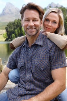 Smile, love and portrait of couple at countryside in summer for vacation, holiday and bonding together. Man, woman and trees with lake for weekend adventure, travel and tourism outdoors in Europe.