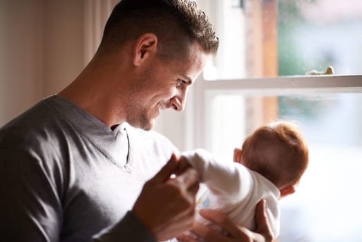 Father, baby and home with bonding, care and support together with family love at a window. Dad, smile and young child in a house with parent with newborn and man happy and proud about infant.