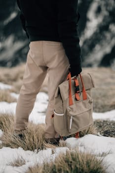 A solitary hiker is captured from behind, ready for a winter adventure in the mountains.