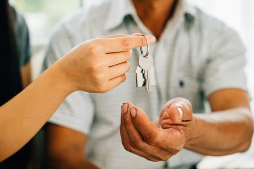 A smiling couple embraces holding keys to their new house signifying happiness success and the joy of becoming homeowners. Reflecting achievement and excitement.