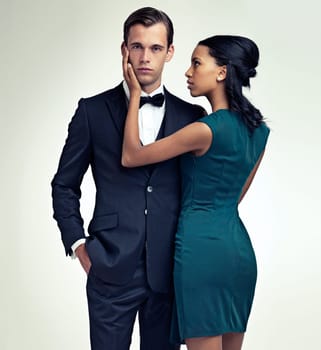 Portrait, man and woman in elegant fashion in studio and confidence in vintage style in mock up. Face, pride or young for interracial couple in formal clothes and touch for care by white background.