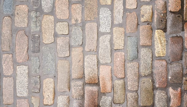 Wet cobblestone or brick stone road, view from above, can be used as texture