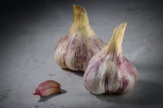 Still life photo of organic whole garlic on a light stone background 1