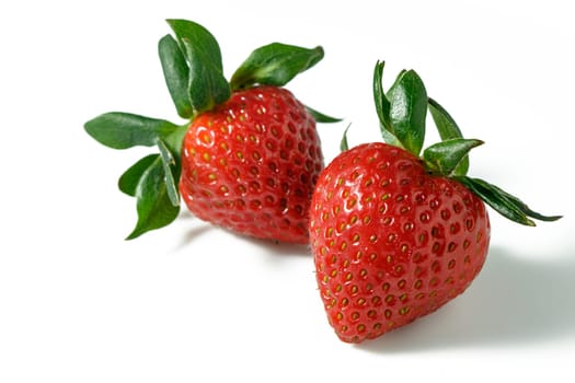 Two strawberries close up on white background